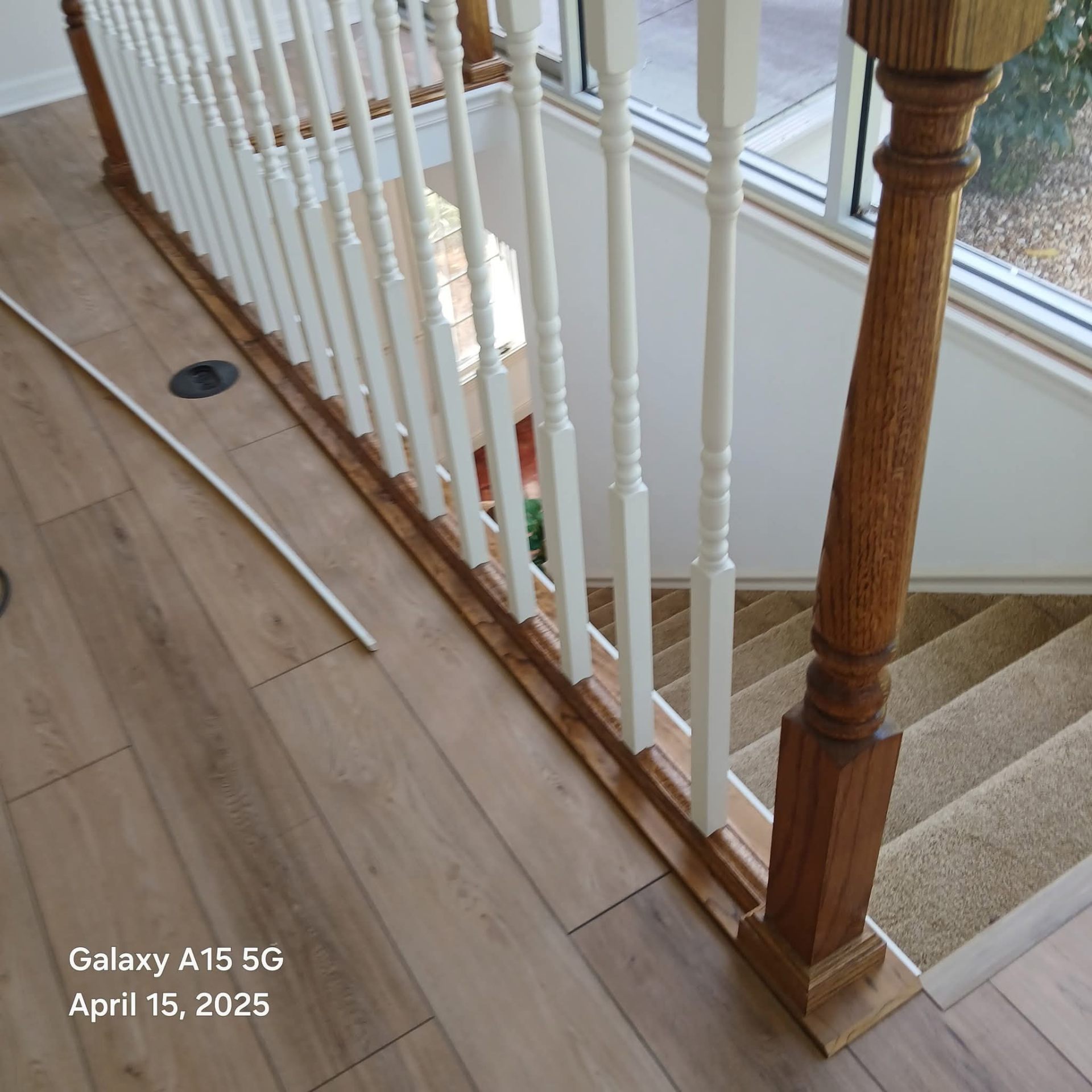 Beautiful hardwood flooring installation with white painted staircase railings