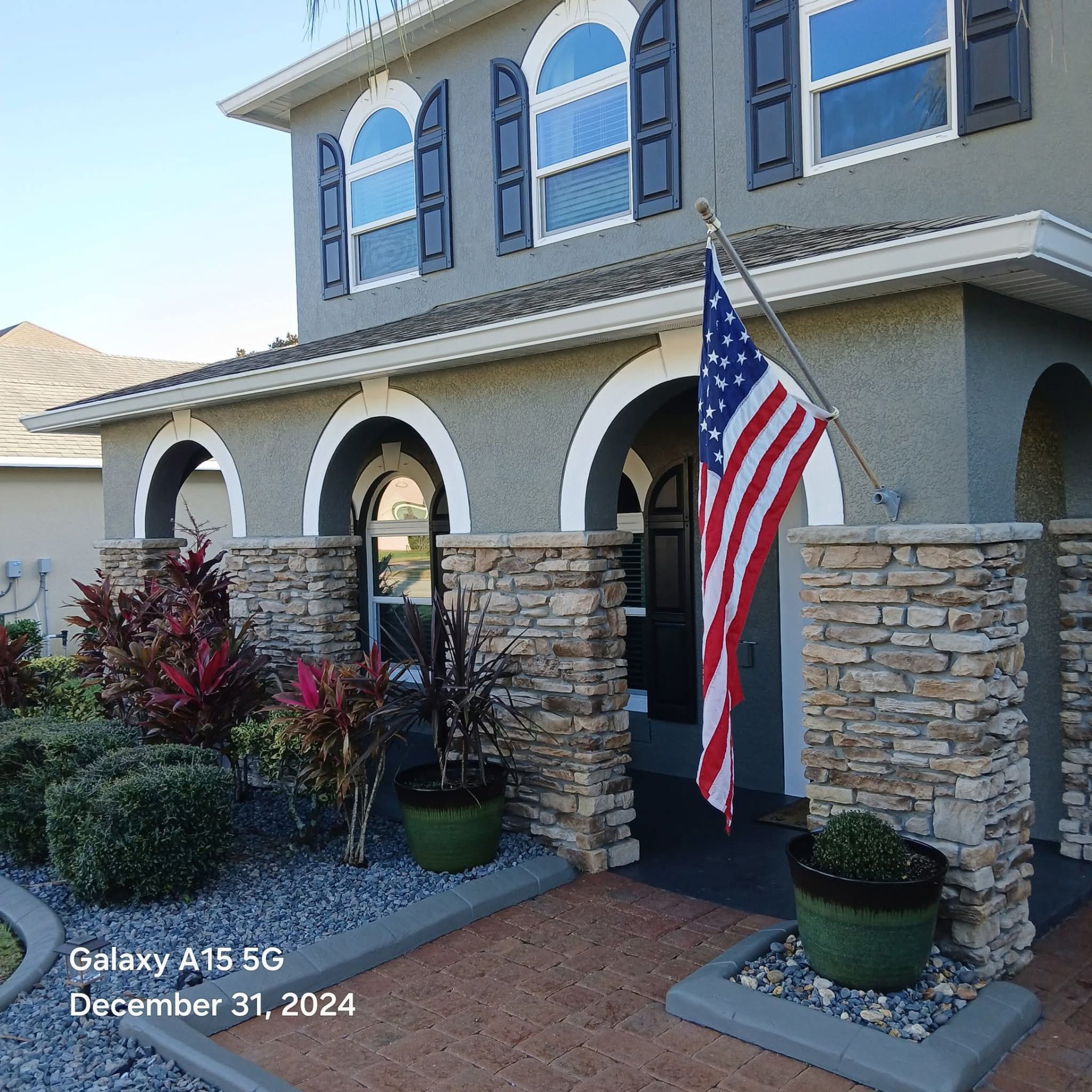 Elegant entry with stone veneer columns and arched details